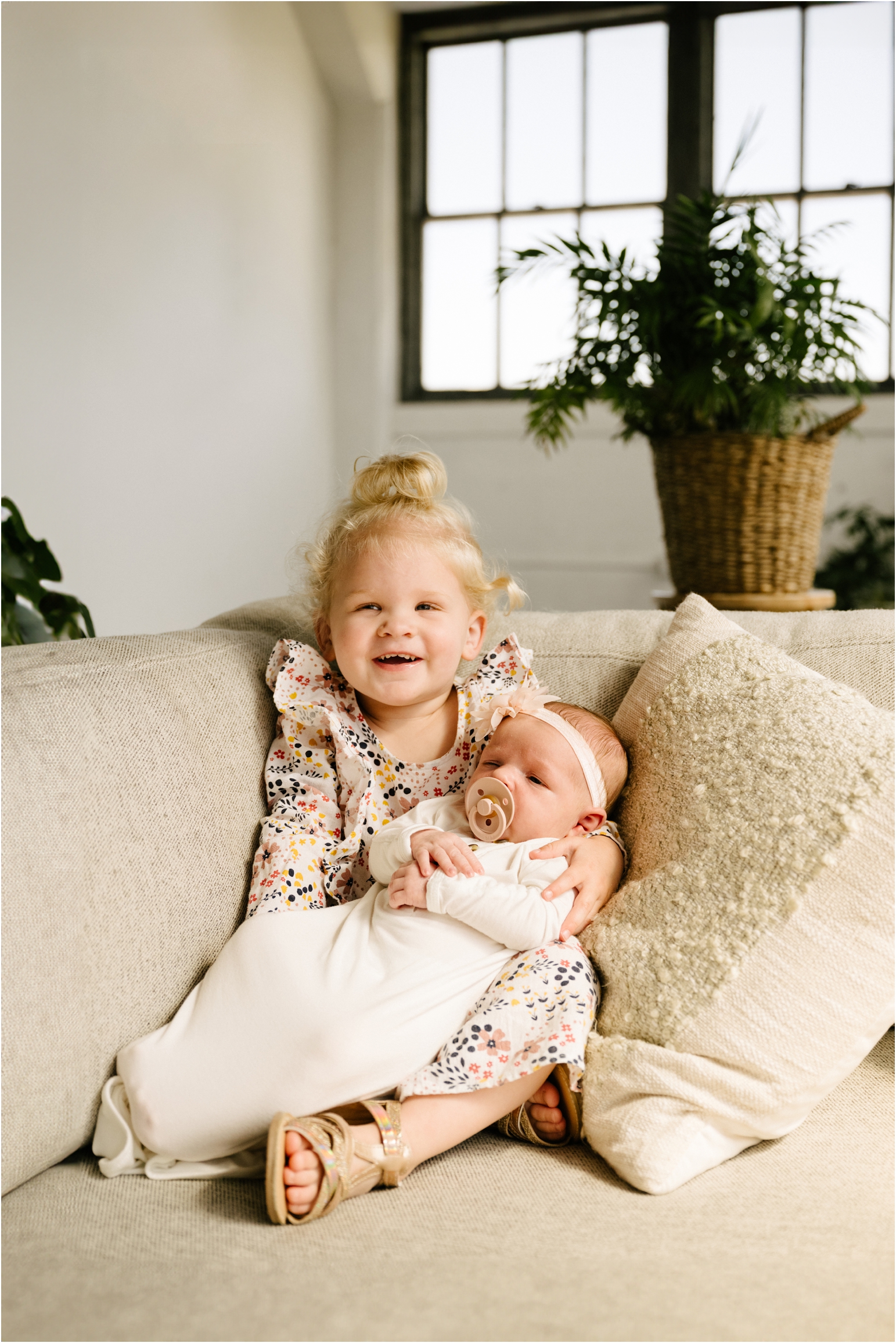 big sister holding infant baby sister